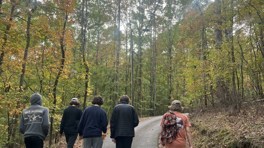 Teens and staff walking a wooded road at Eagle Overlook Recovery in North Georgia